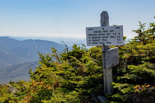 Trail signpost at the Howker–Osgood Junction overlooking a sweeping mountain valley.